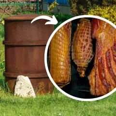 Domowa wędzarnia z beczki w ogrodzie, w której wędzą się pachnące mięsa i wędliny.