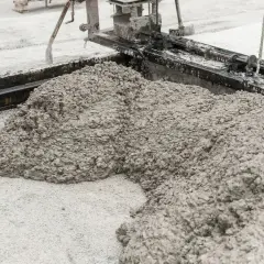 Świeży beton pod kostkę wylewany z betoniarki na plac budowy.