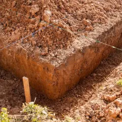 Wykonano wykopy pod fundamenty. Widać głębokie okopy ziemi, wyznaczone sznurkami.