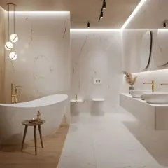 Elegancka łazienka z wanną wolnostojącą i podwójną umywalką. Ściany i podłoga wykończone płytkami gresowymi imitującymi marmur. Złote baterie i oświetlenie dodają luksusu.