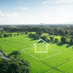 Zielona działka z obrysem domu, symbolizująca potencjalną inwestycję i podatek od sprzedaży działki.