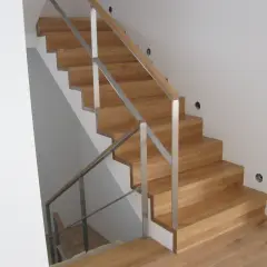 Nowe schody dywanowe na beton, z drewnianymi stopniami i metalową balustradą, tworzą eleganckie i nowoczesne wnętrze.