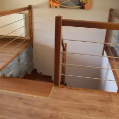 Drewniane schody z metalowymi poręczami, idealne, by zakończyć ostatni stopień schodów.