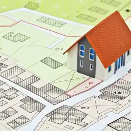 Model domu na mapie działek. Zrozumienie mpzp co to jest, jest kluczowe dla planowania przestrzennego i budowy.