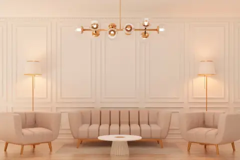 Elegancki salon w stylu glamour: beżowa sofa, dwa fotele, okrągły stolik, lampy podłogowe i designerski żyrandol.