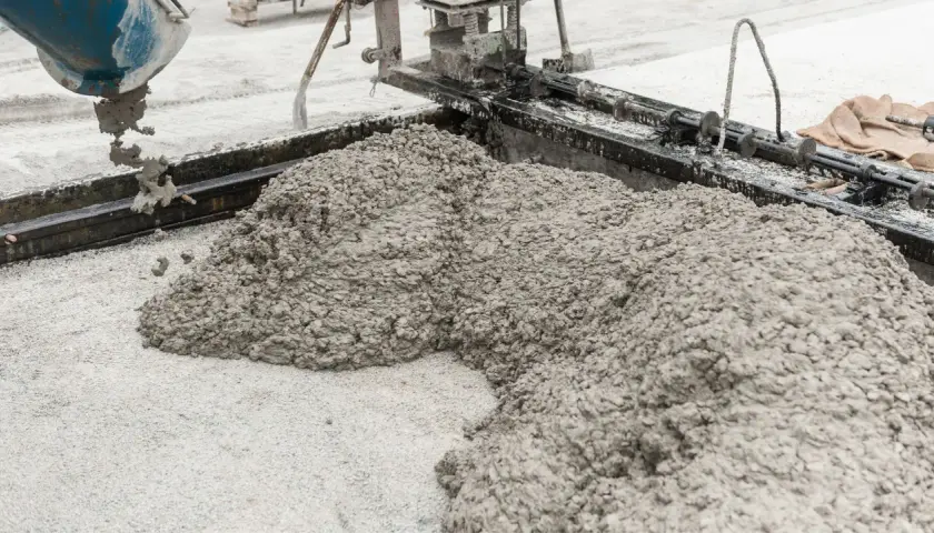 Świeży beton pod kostkę wylewany z betoniarki na plac budowy.