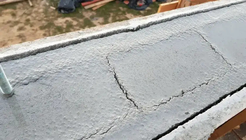Betonowy wieniec budowlany z widocznymi pęknięciami, przygotowany do dalszych prac.