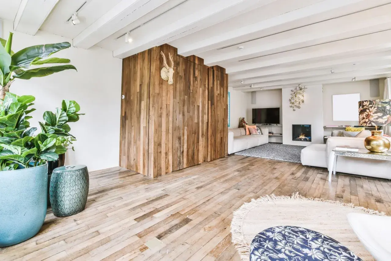 Nowoczesny salon z drewnianą ścianką i podłogą. Płytki drewnopodobne w salonie aranżacje tworzą ciepły klimat.