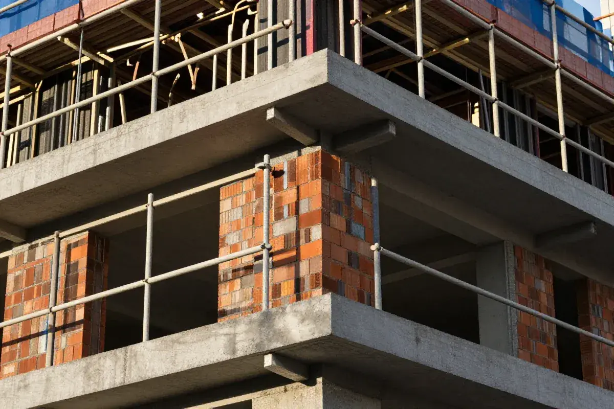 Budowa domu w toku, zbliża się zakończenie budowy domu i wpis do księgi wieczystej. Betonowe stropy i ceglane słupy.