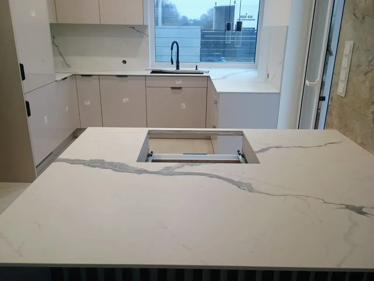 Nowoczesny blat ze spieku kwarcowego z wycięciem na zlew, imitujący marmur.